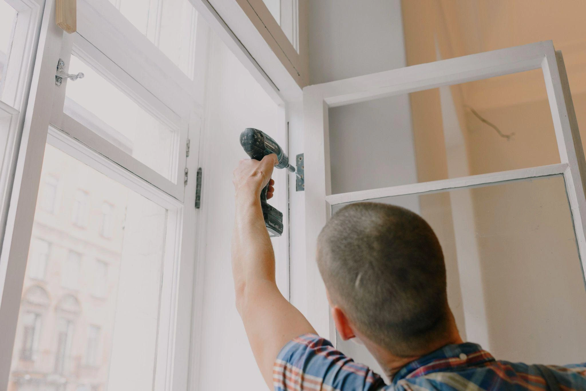 Maintenance professional repairing a window between guest stays.