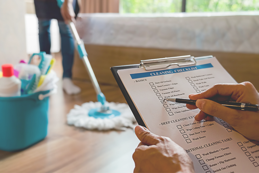 Property manager reviewing cleaning checklist on tablet while inspecting rental property interior