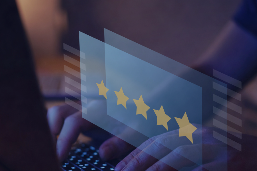Hand typing on laptop with five-star rating displayed on transparent overlay