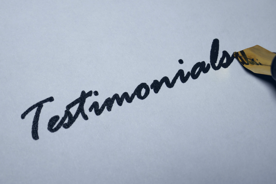 Palavra manuscrita “Testimonials” representando opiniões de clientes sobre um sistema PMS (Property Management System) e soluções tecnológicas para hotelaria.