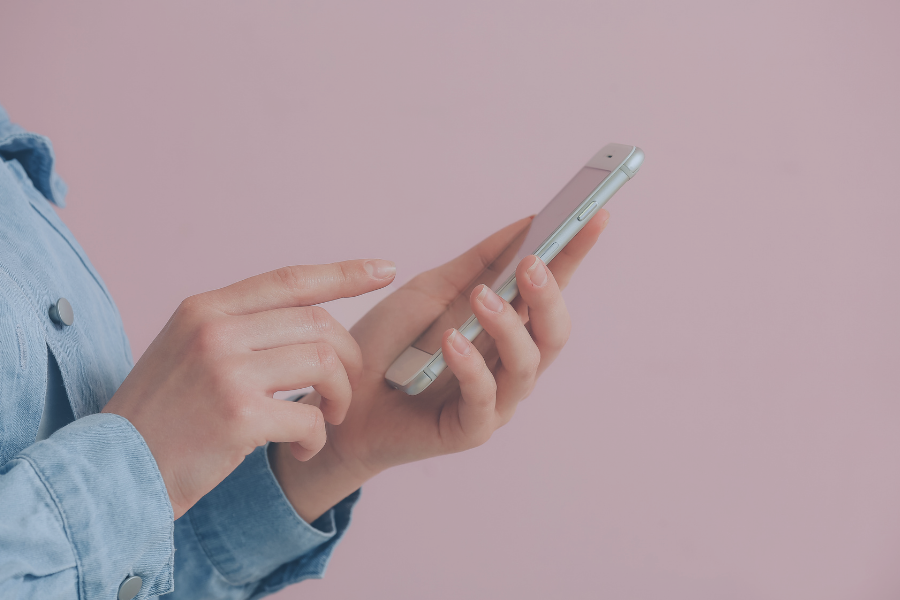 Pessoa usando smartphone para verificação de hóspedes com software de gestão antes do check-in no Airbnb