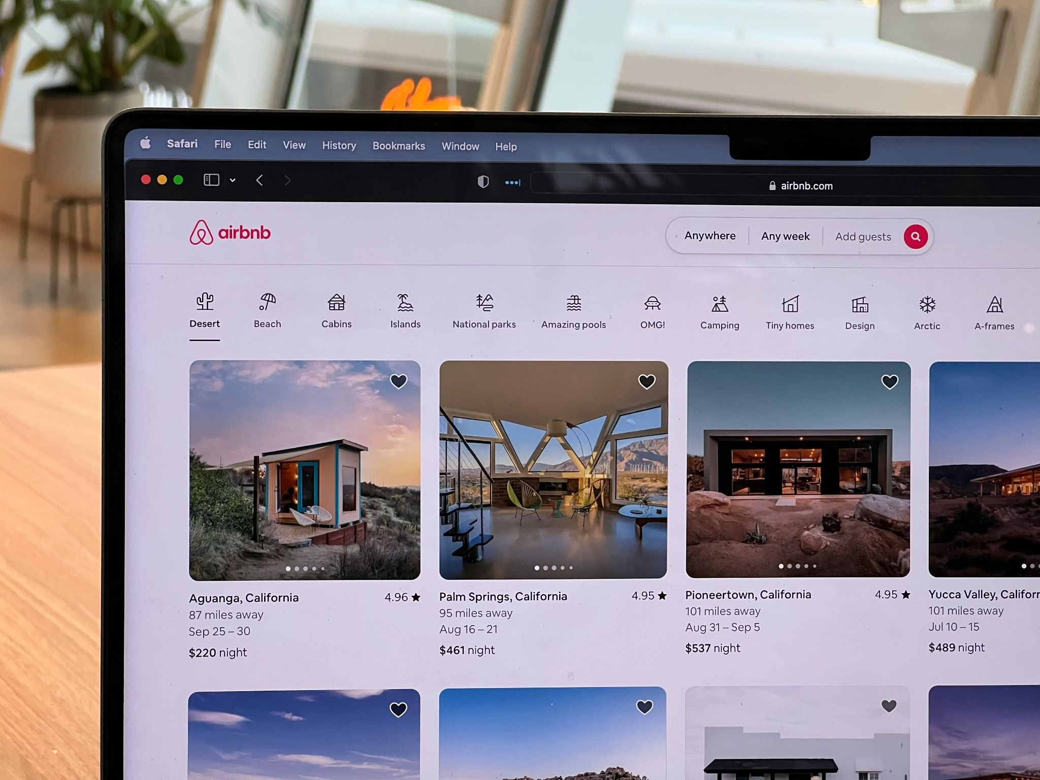 Airbnb website displaying vacation rental listings including desert cabins, beachfront homes, and unique stays in California locations with nightly rates and availability dates.