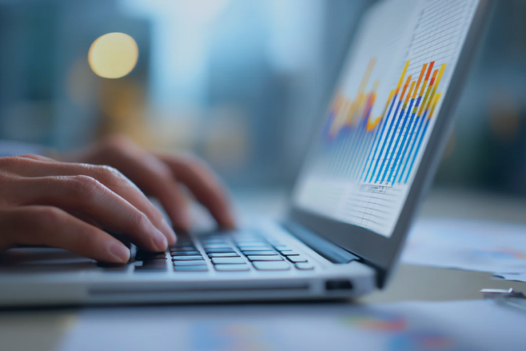 Analyst reviewing performance charts and data graphs on laptop screen during financial analysis session