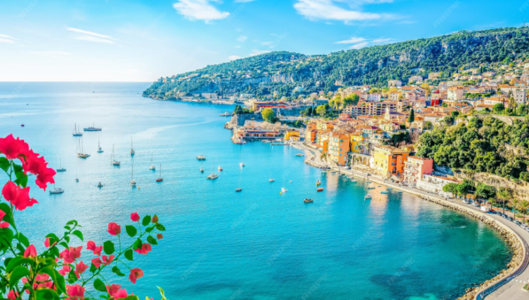 Mediterranean coastal town with turquoise waters and hillside buildings, typical holiday destination for short-term rental properties