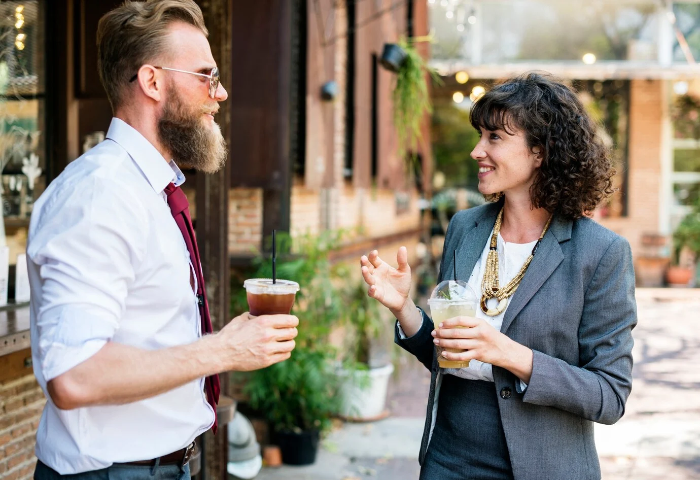 Two property management professionals discussing business strategy at outdoor event with branded backdrop