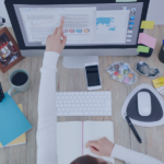 anized home office setup with a person analyzing property management software on a desktop screen.