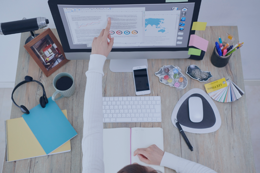 anized home office setup with a person analyzing property management software on a desktop screen.