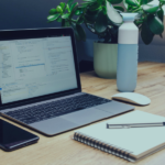 Workspace with laptop and notebook illustrating customizable templates for guest communication for property managers