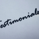 Mot manuscrit “Testimonials” symbolisant les avis clients liés à un PMS property management system et à des hospitality technology solutions.