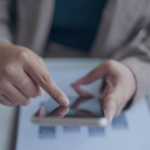 Personne utilisant un smartphone pour un enregistrement automatisé via un logiciel de gestion dans une propriété Airbnb