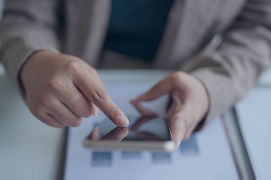 Personne utilisant un smartphone pour un enregistrement automatisé via un logiciel de gestion dans une propriété Airbnb