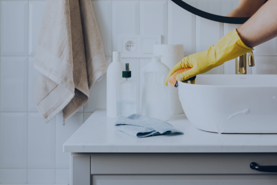 Cómo gestionar equipos de limpieza a distancia con software de gestión mientras limpian un baño de Airbnb.