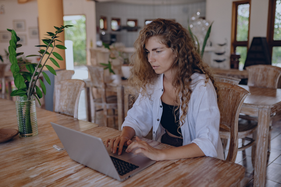 Woman managing Airbnb bookings on laptop while handling cancellations using software