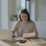 Chica revisando en su laptop un documento sobre cómo rastrear reservas de Airbnb con software de gestión