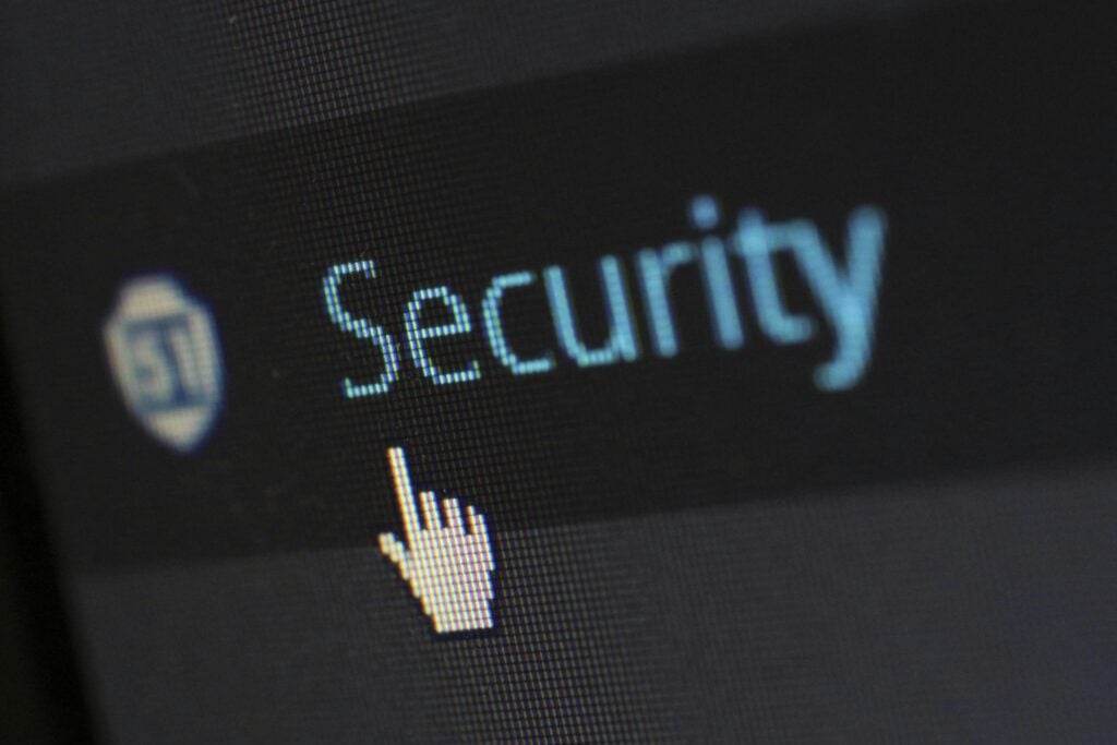 Palavra Security com cursor de rato em ecrã de computador, representando proteção de dados e segurança digital