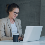 Gestionnaire de propriété travaillant sur son ordinateur portable avec une tasse de café au bureau