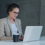 Property manager reviewing vacation rental operations on laptop while working remotely from home office