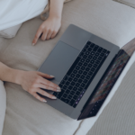 Person using laptop to manage vacation rental bookings on sofa