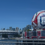 Ballon de football FIFA géant avec logo rouge et bleu devant le stade BC Place et la skyline de Vancouver
