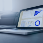 Laptop displaying property management dashboard with occupancy charts, revenue analytics, world map data and performance metrics in blue